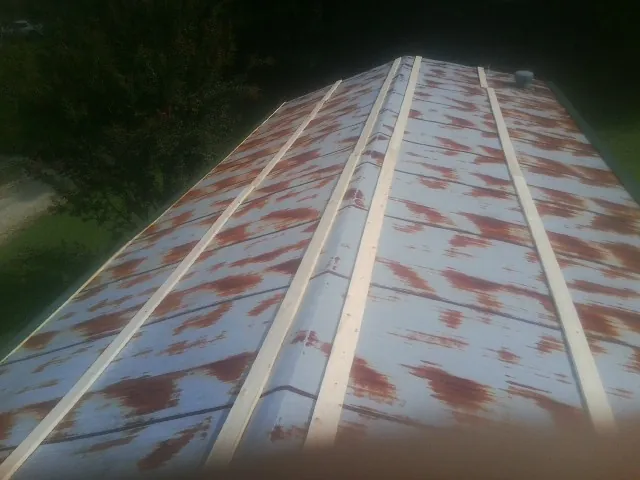 Rusted metal roof panels with new wood purlins before replacement — Storm Damage Roof Repair in Mullens by Roofing Brothers