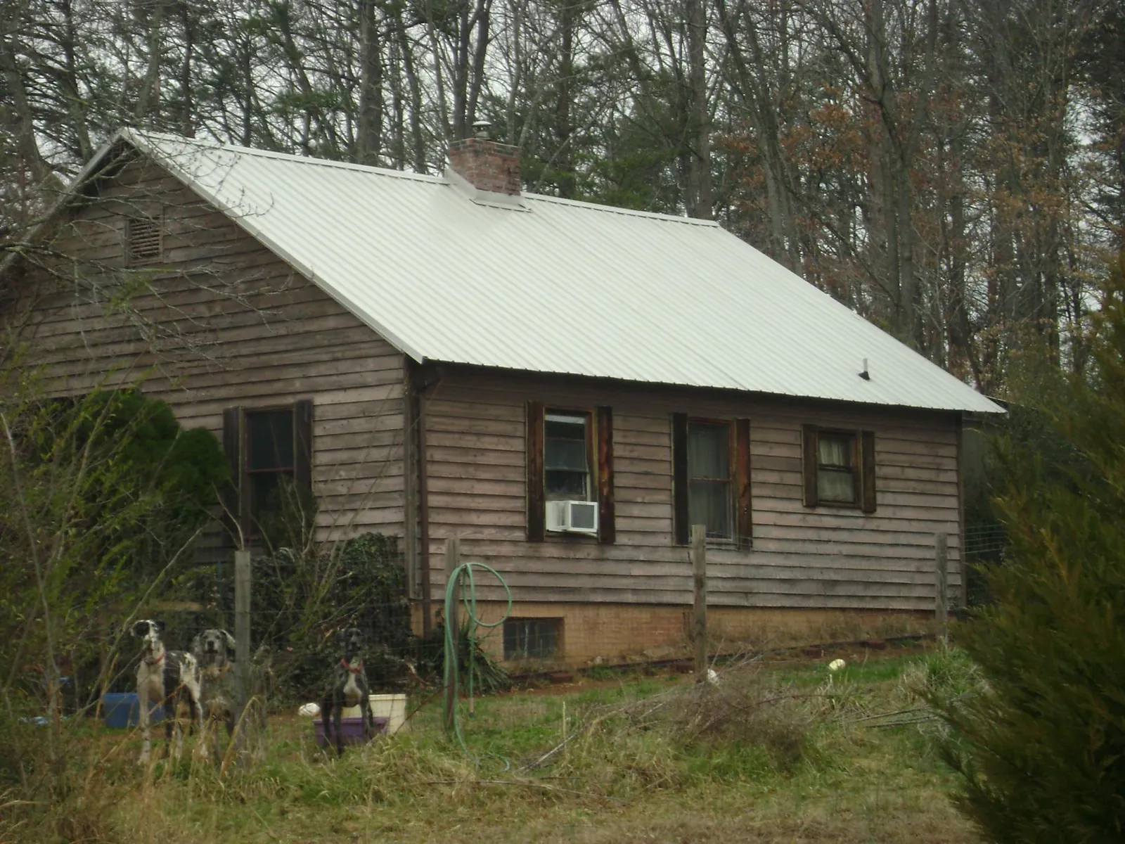 White metal roof on an old wood sided farmhouse, from a Metal Roof Installation job in Mullens